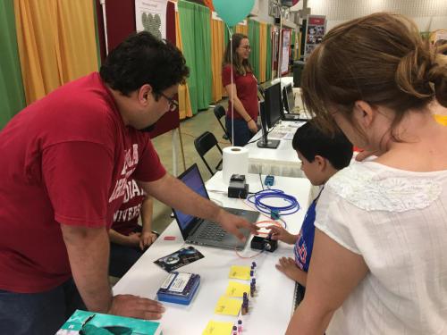 Ye group member describing their presentation to visitors