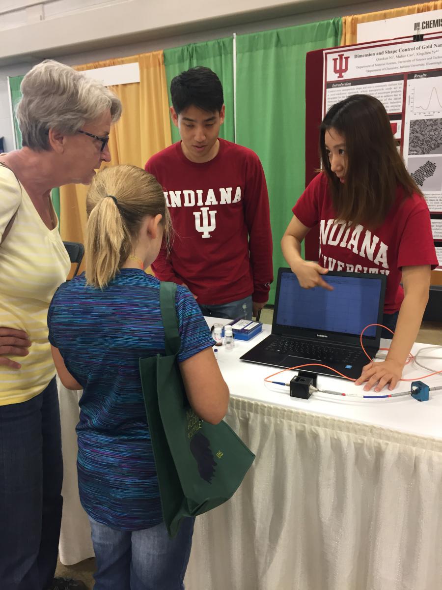 Ye group members presenting laptop information to visitors