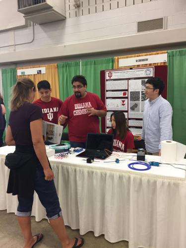 Xingchen Ye watching on as his group member describes their presentation to visitors